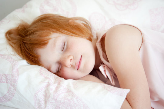 Red-haired girl pretending to be asleep