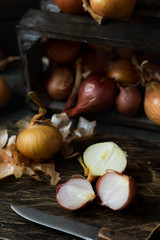 Onion in a wooden box on a dark background