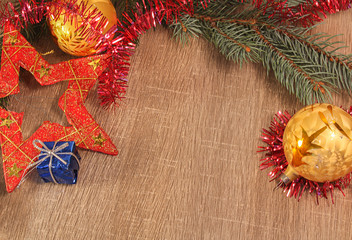 Gold bal, red starl and blue gift with coniferous branch on wood background © Space Creator