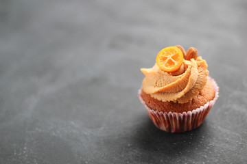 Cream caramel cupcake on black board decorated by almonds