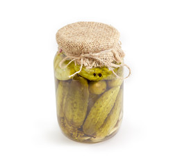 Canned cucumbers in glass jar on a white background