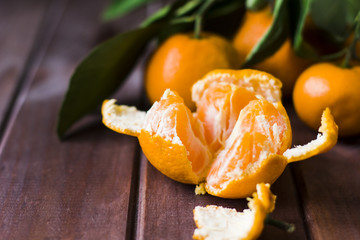 Fresh opened tangerine on wooden background