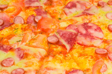 Fragment of the pizza with different sausages closeup