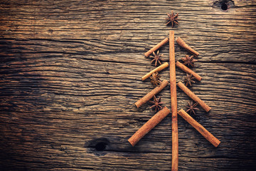 Christmas tree from cinnamon star anise and walnuts on rustich wooden table