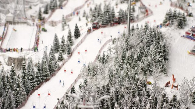 Overview of the ski lifts from snow-covered forest and snow catchers on ski resort in slow motion. 3840x2160