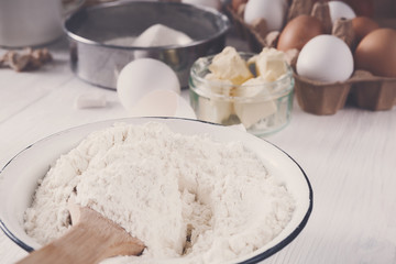 Making dough, baking. Bowl with flour on wood desk
