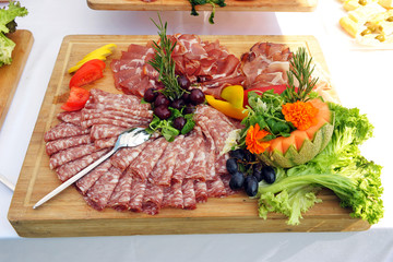 Wooden tray with salami. Buffet. Pancetta. Catering