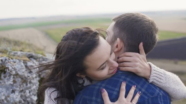 Lovely man embraces and kisses his woman on nature. 4K