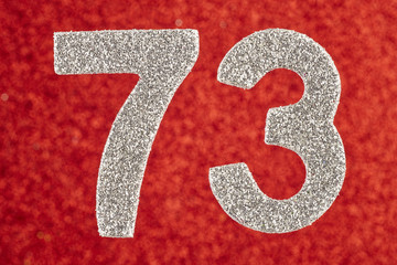 Number seventy-three silver color over a red background. Anniversary