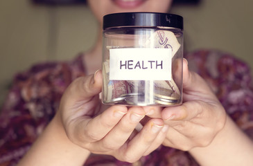 Algerian woman with beautiful smile hold a plastic pot and saving money for health