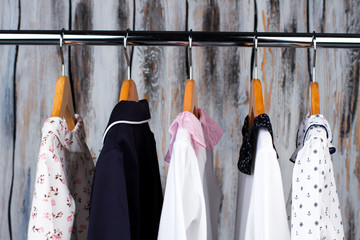 Kids pajamas in a wardrobe. Clothes on wooden hangers. Fashion for little ones, sleepwear and robes.