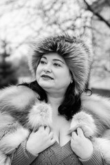 Cute and beautiful mature plus size woman in fur coat on winter background. Life after 40 years for womens. Large and gorgeous beauty. 