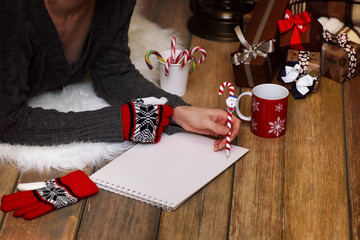 girl writes pen on a piece of paper Christmas wishes
