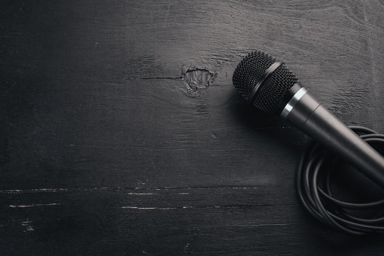Microphone on a wooden black table. Studio. Top view. Free space for text. Copy space.