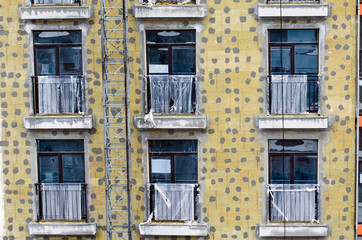 The windows of the constructed building, and the pointwise applied cement finish.