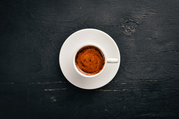 A cup of espresso coffee on a dark wooden background. Top view. Free space for text.