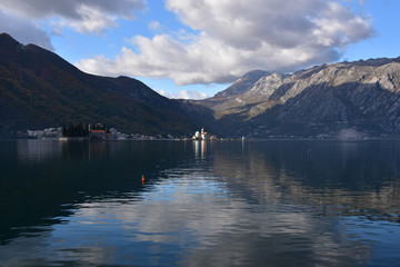 Situated on a small islet in the bay of Kotor, Montenegro - the church of Virgin Mary lit by sunlight; St George islet hidden in shadow