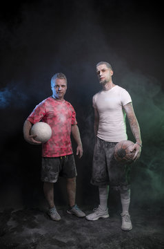 Studio portrait of sportsmen using balls