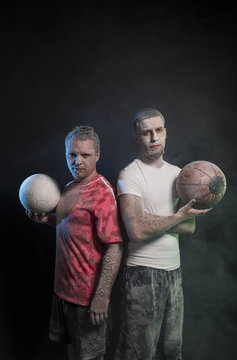 Studio portrait of sportsmen using balls