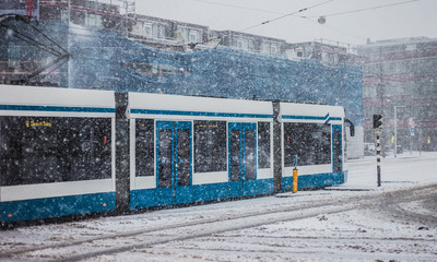 Fototapeta na wymiar Tram in Amsterdam on snowy day