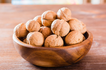 Plate with walnuts on a wooden table