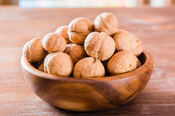 Obraz premium Plate with walnuts on a wooden table