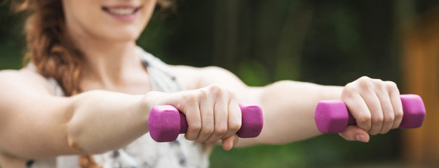 Woman exercising with purple dumbbels