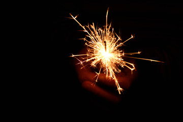 Blank background with bengal fire .Sparkler . New year party sparkler on black background A man holds a burning Bengal flame in his hands