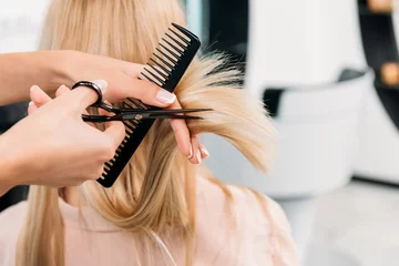 Keuken foto achterwand Schoonheidssalon cropped image of hairdresser trimming ends of blonde hair