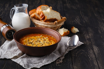 Serving on rustic table,  traditional seasoning pumpkin soup in bowl
