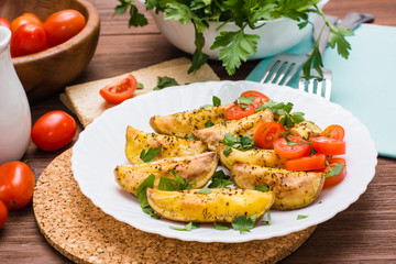 Baked potatoes with ripe tomatoes and fresh herbs on a plate