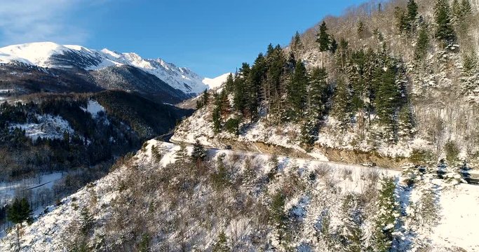 Vue a&eacute;rienne d'une voiture sur une route de montagne - voiture route chemin roche arbre neige dangereux ciel bleu
