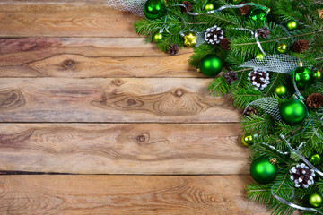Christmas garland with green baubles on the wooden background, copy space.