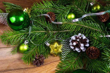 Fototapeta na wymiar Christmas background with green baubles, fir and pine cones