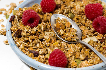 sweet granola on the plate and fresh raspberries
