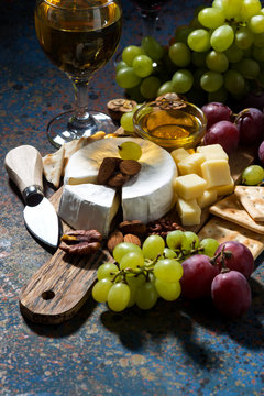 snacks, wine and camembert on a dark background, vertical