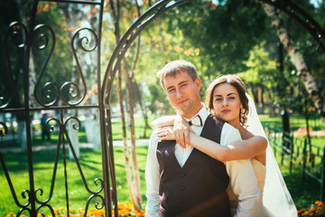 The bride and groom in the park arch