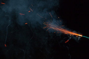 Burning fuse with sparks and grey smoke on black background