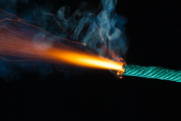 Burning fuse with sparks on black background
