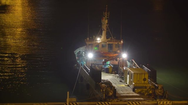 15444 A small cargo boat with the lights on