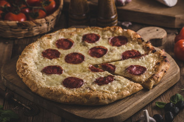 Rustic pizza with tomato, cheese, salami