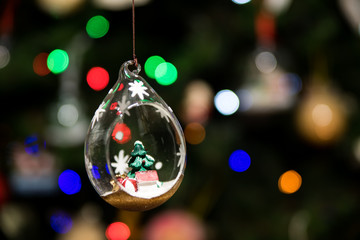 Fototapeta na wymiar Small Christmas tree inside glass ornament hanging on Christmas tree