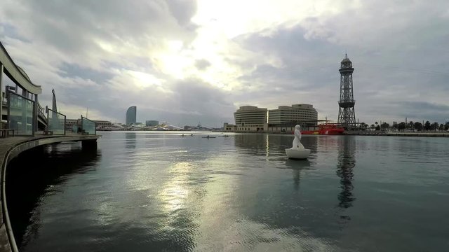 This is footage of still water in a port area of a big city. This is the private ship port part with sails and so on. Wooden floor and eary sunset.
