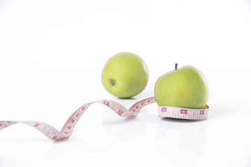 green apple with measure tape on white background. concept nutrition healthy.