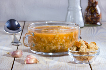 Soup with meat and rice on the plate on wooden table