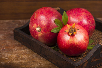 Fototapeta na wymiar Ripe pomegranate fruits on the wooden background