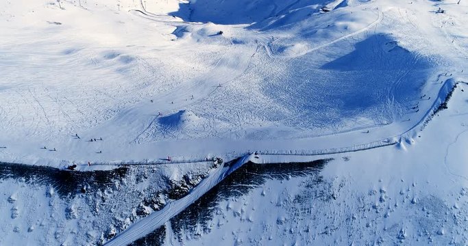 Vue a&eacute;rienne d'une piste de ski avec des skieurs sur une montagne enneig&eacute;e - neige monter descendre montagne vacances tourisme voyage sport soleil