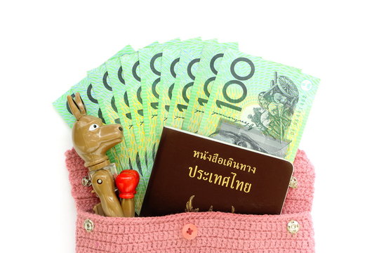 Top view of Australian cash money with Thai passport and kangaroo pen out from pink bag on white background. Concept travel by yourself or tour or go to learn at Australia