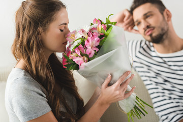 young woman with beautiful bouquet presented by boyfriend