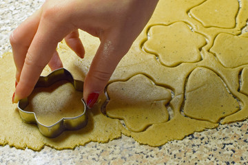 Christmas baking. Making traditional Christmas cookies, gingerbread. Close up of hand, cutter and...